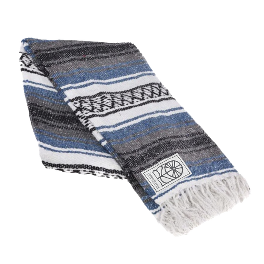 A striped gray authentic Mexican blanket with fringes and a visible brand tag.