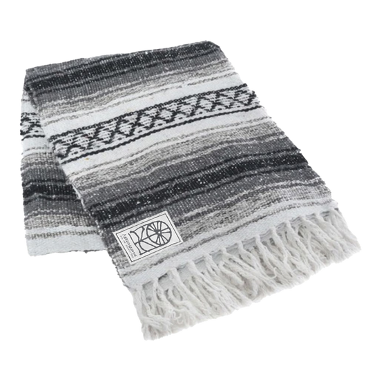 A striped gray authentic Mexican blanket with fringes and a visible brand tag.