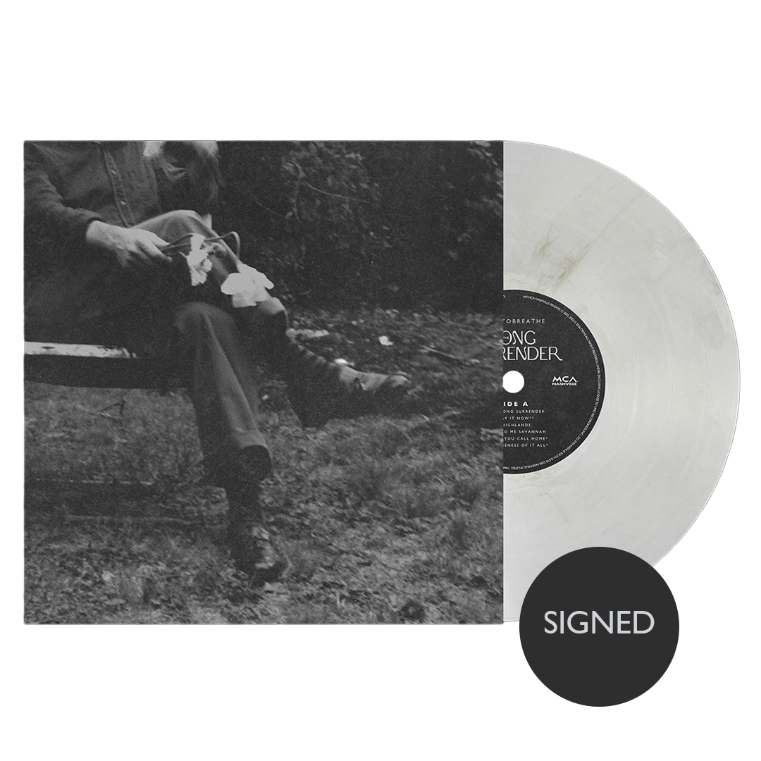 Vinyl record with a person sitting in nature and a 'SIGNED' label.